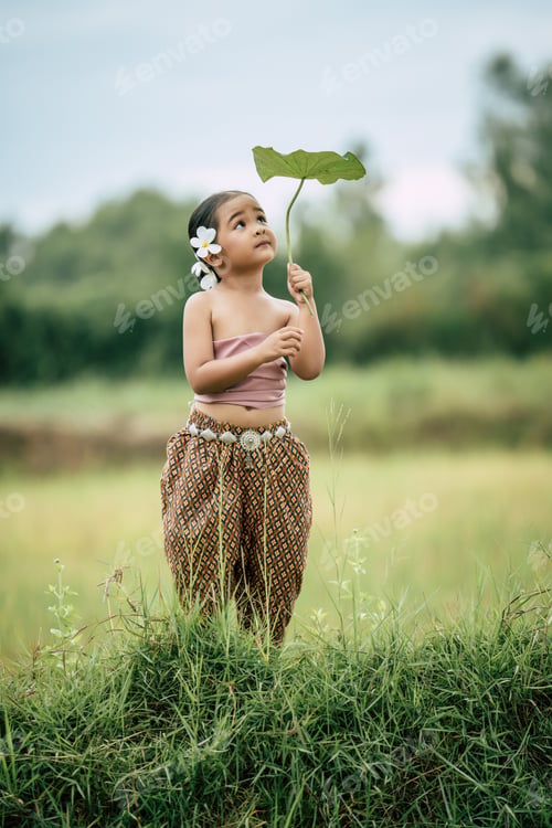 Preview: Cute girls in Thai traditional dress holding leaf of lotus