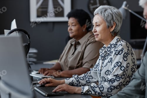 Preview: Asian senior woman using computer and smiling in school for elderly people