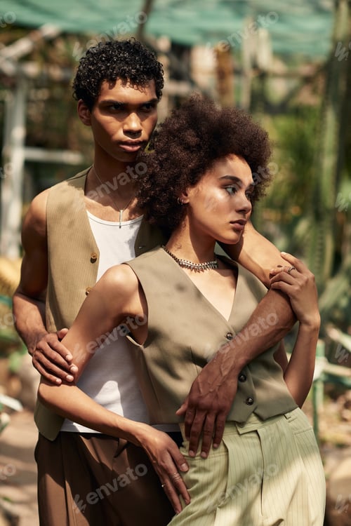 Preview: Young couple embracing in a lush greenhouse surrounded by vibrant green plants