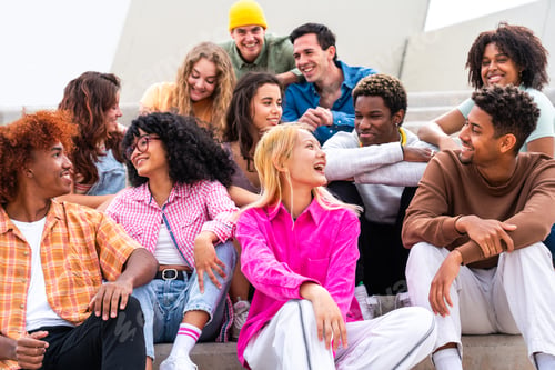 Preview: Happy playful multiethnic group of young friends bonding outdoors