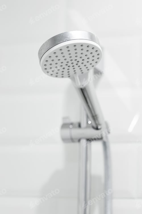 Preview: Showerhead viewed from below in a modern bathroom with white tiles and clean design