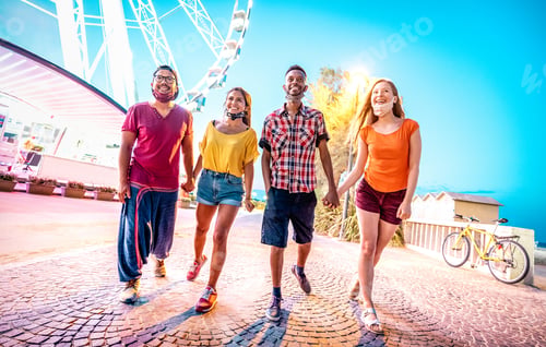 Preview: Happy multiracial couples walking with open face masks after lockdown reopening