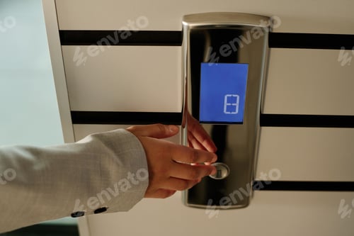 Preview: Businesswoman pushing button of elevator