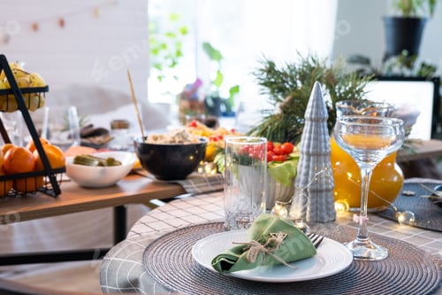 Preview: Serving a festive table with snacks, salads and goodies close-up in the modern interior of a loft ho