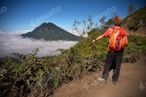 Preview: Rear view of the woman looking at clouds from caldera of Ijen volcano, Indonesia