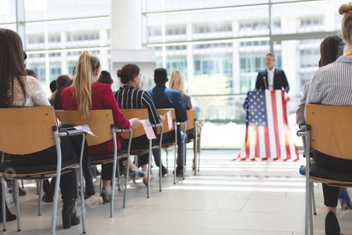 Preview: Businessman speaks at a business seminar in office building with american flag