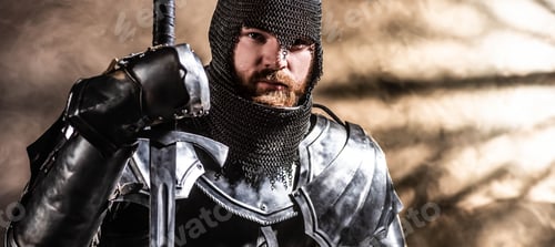 Preview: panoramic shot of handsome knight in armor holding sword on black background
