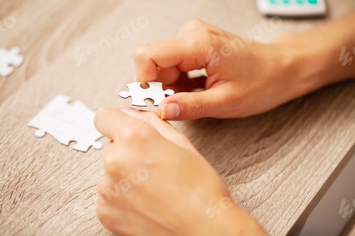 Preview: Closeup hands of man connecting jigsaw puzzle.