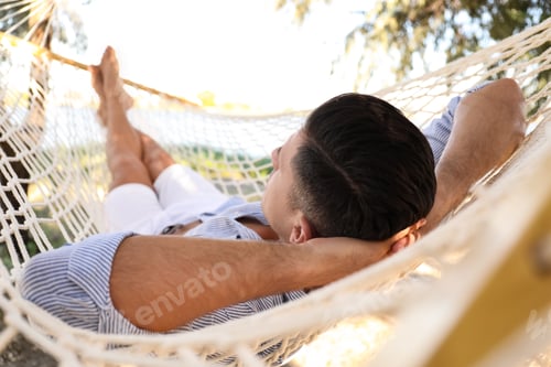 Preview: Man relaxing in hammock on beach. Summer vacation