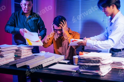 Preview: Three young businessmen work together on laptops in the office at night. They are stressed tired