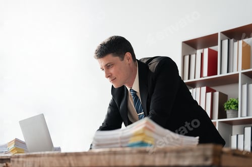 Preview: Young businessman working with laptop at office