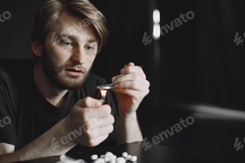 Preview: Addict preparing drug dose for injection in dark room