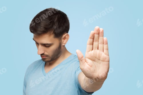Preview: Young man showing stop gesture with hand