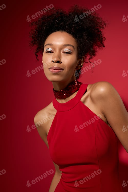 Preview: Beautiful young woman radiates joy in a vibrant red setting, capturing bliss in her expression