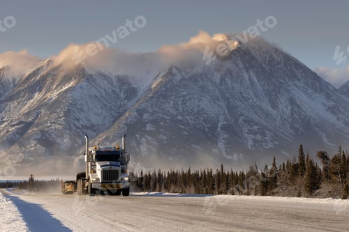 Preview: Oversize load truck in the road with forests and snowy mountains in Whitehorse, Yukon, Canada
