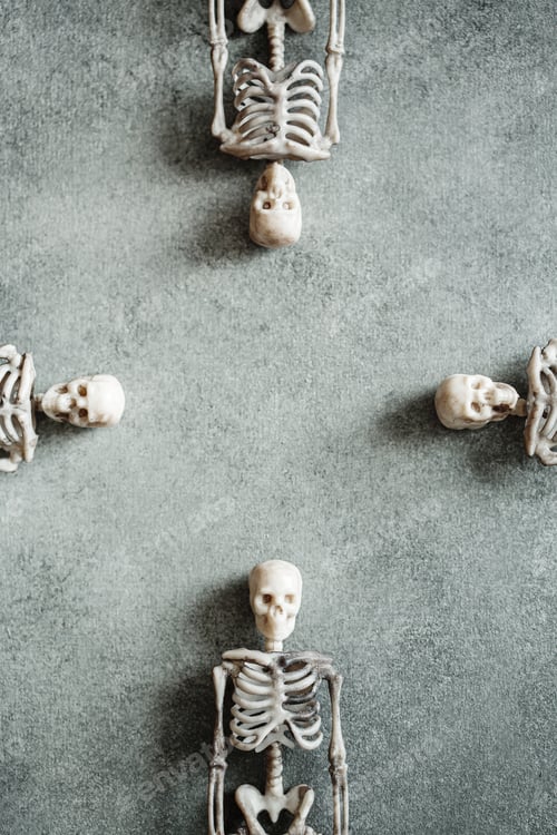 Preview: Group of little toy skeletons over grey background making frame, minimalistic Halloween concept