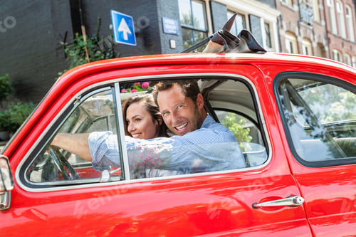 Preview: Netherlands, Amsterdam, happy couple with small car in the city