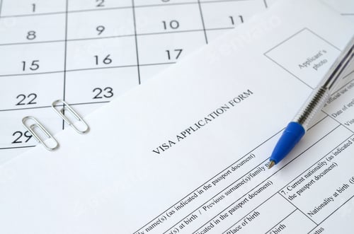 Preview: Typical Visa application form and blue pen on paper calendar page close up