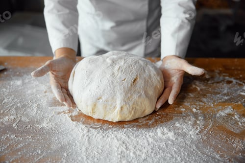 Preview: Closeup baker hands holding kneaded dough to prepare fresh bread