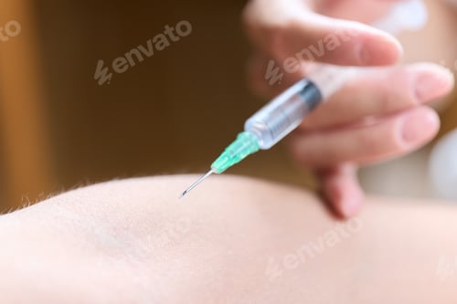 Preview: Asian doctor making an injection in his arm
