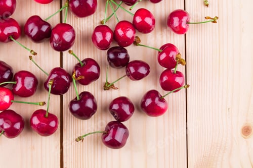 Preview: Fresh cherries on wooden table in the closeup.