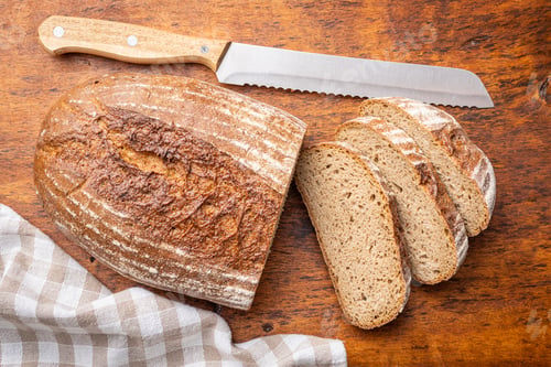Preview: Sliced loaf of bread on wooden table.