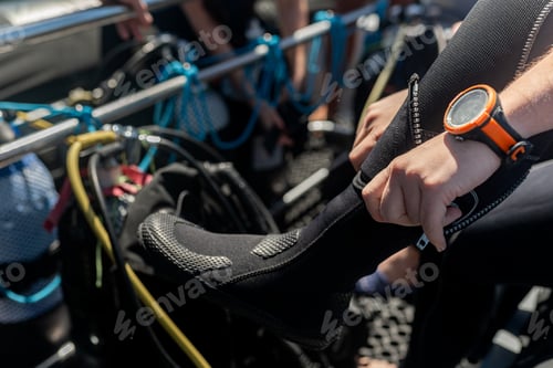 Preview: Diver wearing diving boots and dive computer on boat getting ready for scuba diving