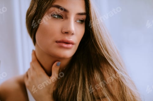Preview: Young long hair female brunette in front of the window