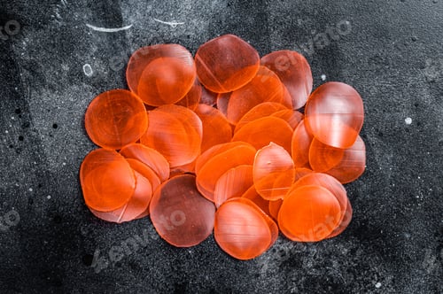 Preview: Raw kerupuk or prawn shrimp crackers, chips. Black background. Top view