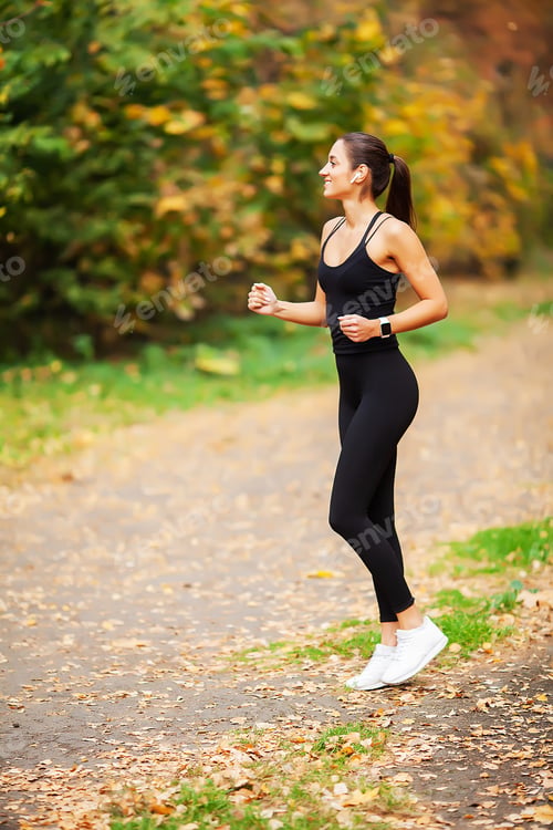 Preview: Woman Listening Music On Phone While Exercising Outdoors