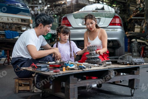 Preview: Asian family of mechanic enjoy to have good activity together in garage with father and mother