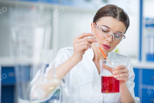 Preview: Concentrated woman scientist making experiment in chemical laboratory