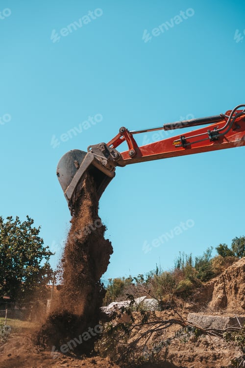 Preview: Closeup of a backhoe with dirt against sky