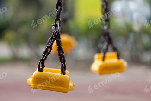 Preview: Yellow swings at the children’s playground, closeup. Sweet memories of the childhood.