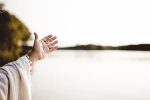 Preview: Closeup shot of a person wearing a biblical robe with a hand up and a blurred background