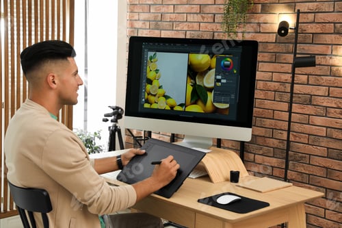 Preview: Professional retoucher working on graphic tablet at desk in office