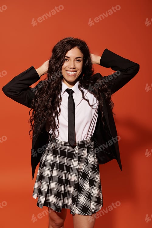 Preview: Young student radiating confidence with stylish outfit and warm smile against vibrant backdrop