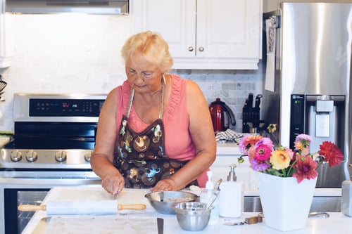 Preview: A woman is baking in a bright white modern kitchen