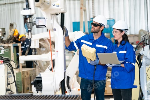 Preview: Robotics engineer working on maintenance of modern robotic arm in factory warehouse