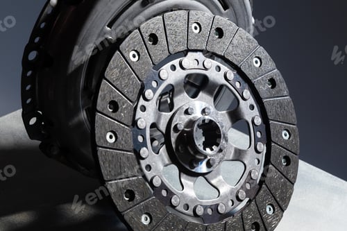 Preview: Close-up picture of a part of car, black clutch disk isolated on black background with light
