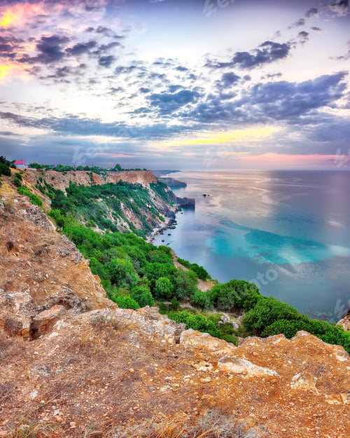 Preview: Mesmerizing sunset at cape Fiolent with bushes grass and rocks at foreground