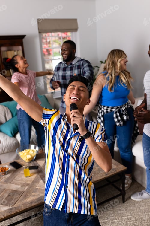 Preview: Happy diverse friends dancing and karaoke singing with microphone at home