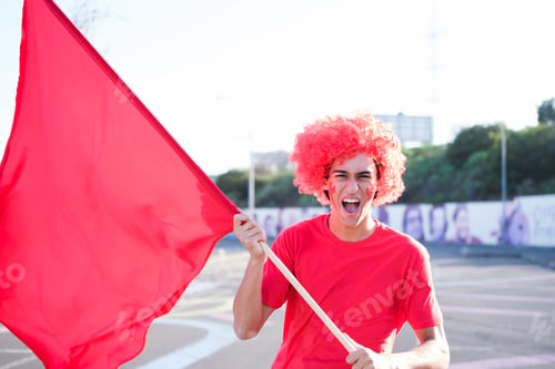Preview: Young man defending his team colors waving the flag while shouting his support