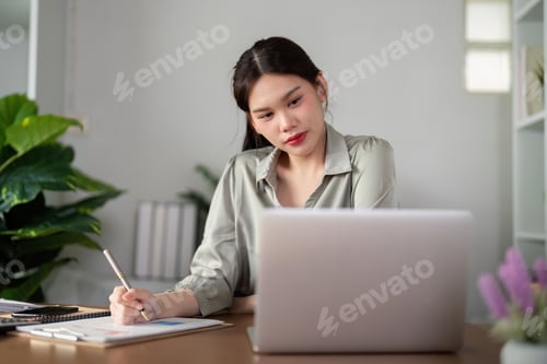 Preview: Asian Businesswoman using laptop computer and working at home with calculator document on desk