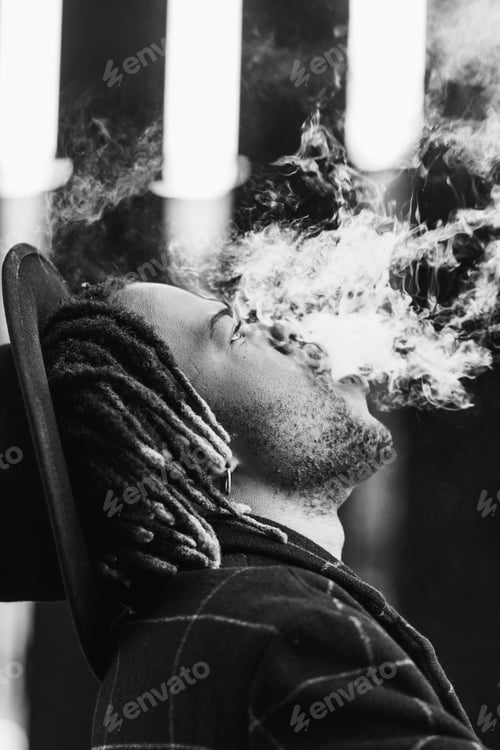Preview: Black man exhaling cloud of smoke on street