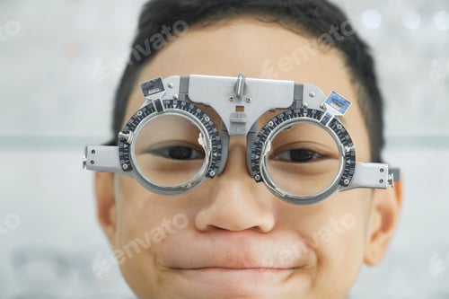 Preview: Young boy examining eyesight in optical clinic.