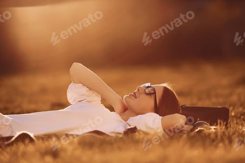 Preview: Illuminated by sunlight. Young girl is on the field at daytime having nice weekend