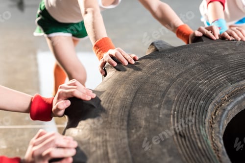 Preview: adorable kids in sportswear training with tire at fitness studio, children sport concept