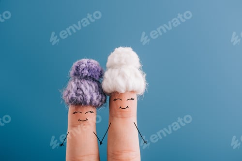 Preview: cropped view of fingers as friends in knitted hats holding hands isolated on blue