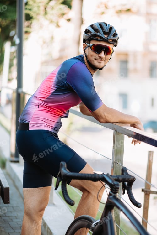 Preview: Man in sportswear standing near black bike outdoors